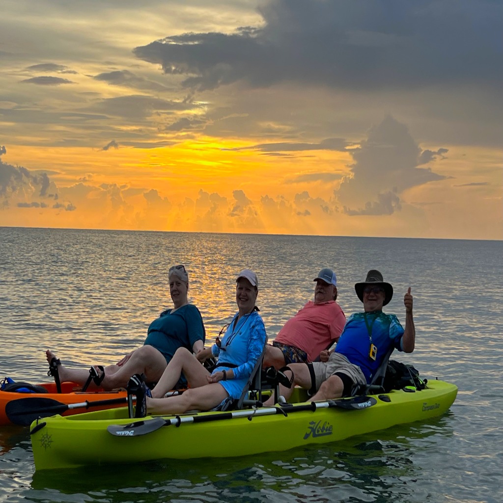 people on kayaking tours at sunset